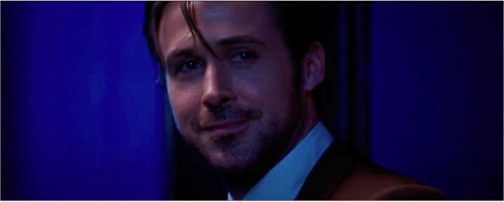 Close-up of Ryan Gosling standing against a blue background